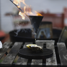 Load image into Gallery viewer, Flambadou basting an oyster