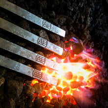 Load image into Gallery viewer, Hand forging skewers on a bed of coals
