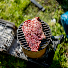 Load image into Gallery viewer, uncooked steak on cast iron chimney bbq grill 
