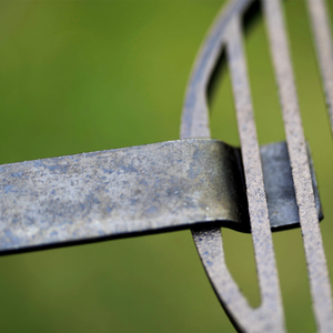 Close up of universal grill handle gripping a cast iron grill