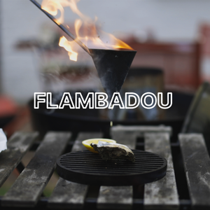 Flambadou basting an oyster with text over lay